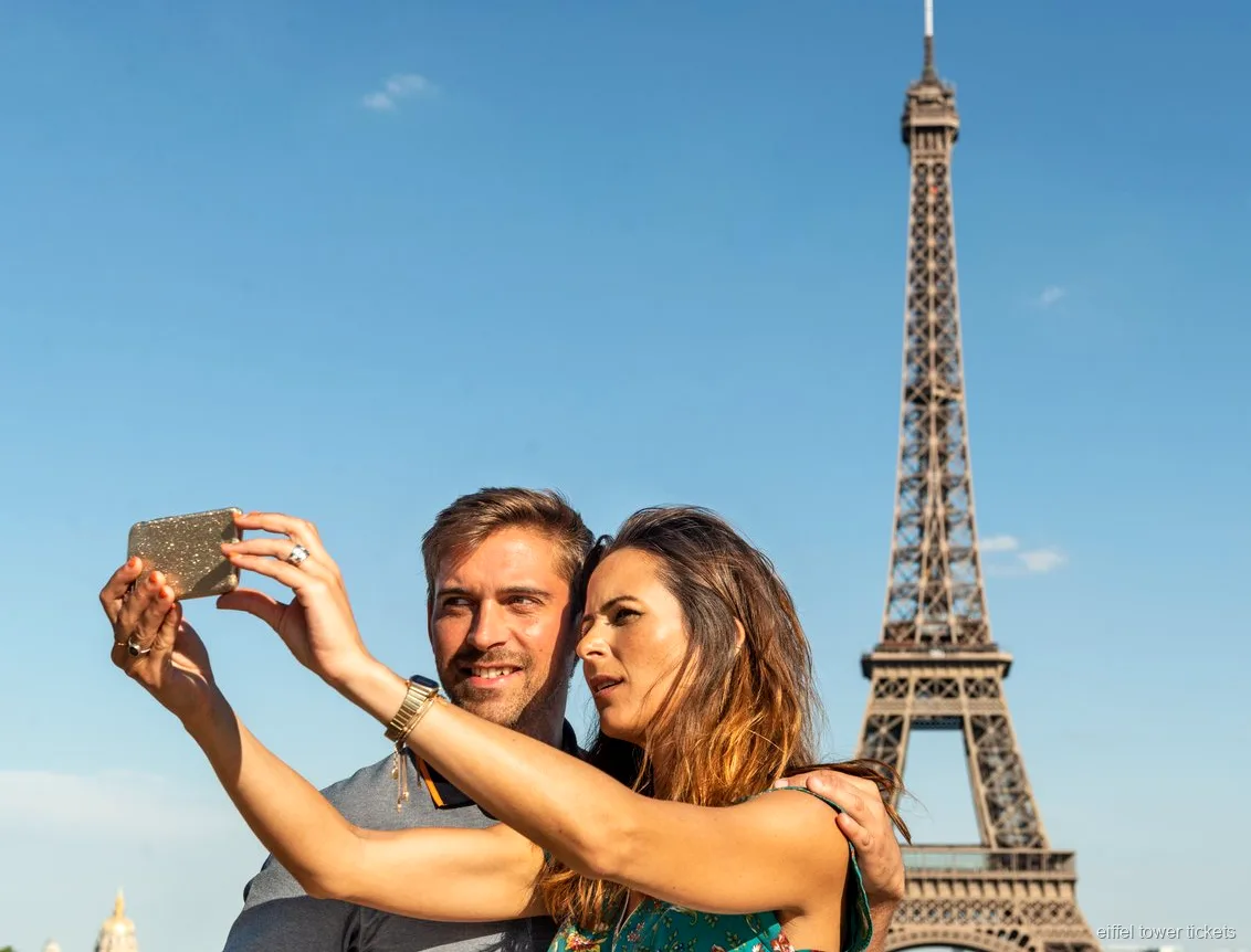 Visitantes com bilhetes da Torre Eiffel a olhar para o rio Sena