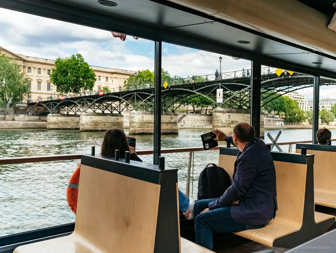 Beleuchteter Eiffelturm von einer Seine Bootsfahrt aus gesehen