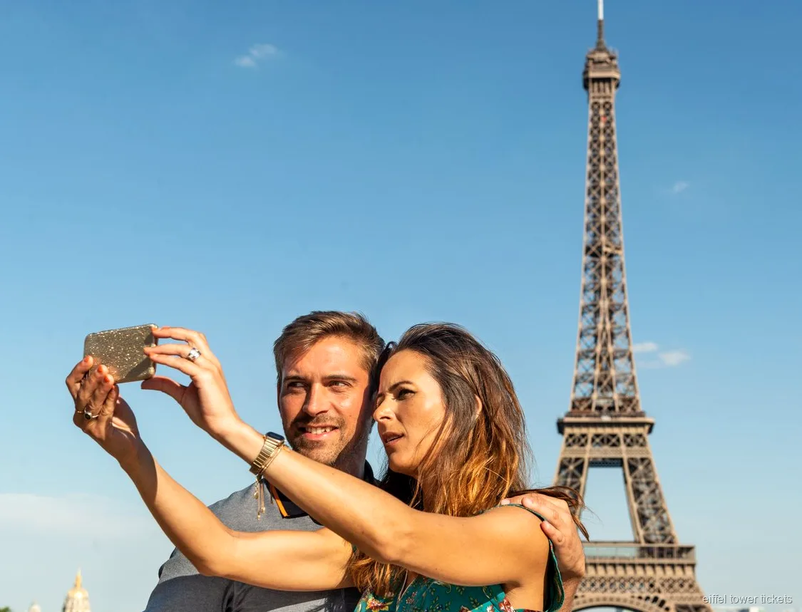 Visitants amb entrades de la Torre Eiffel mirant el riu Sena